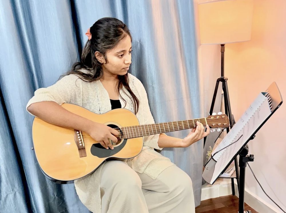 Chandy Taduri playing acoustic guitar